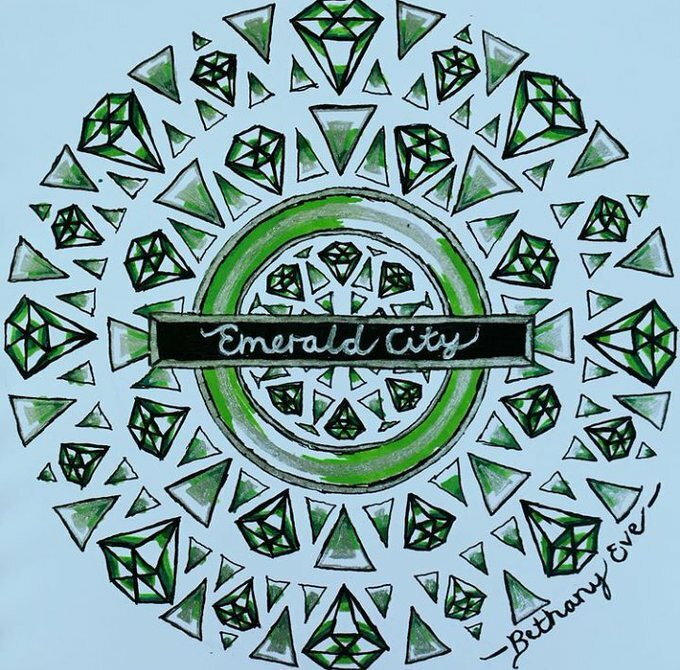 A circular pattern of green and white geometric shapes surrounds the words Emerald City at the center.