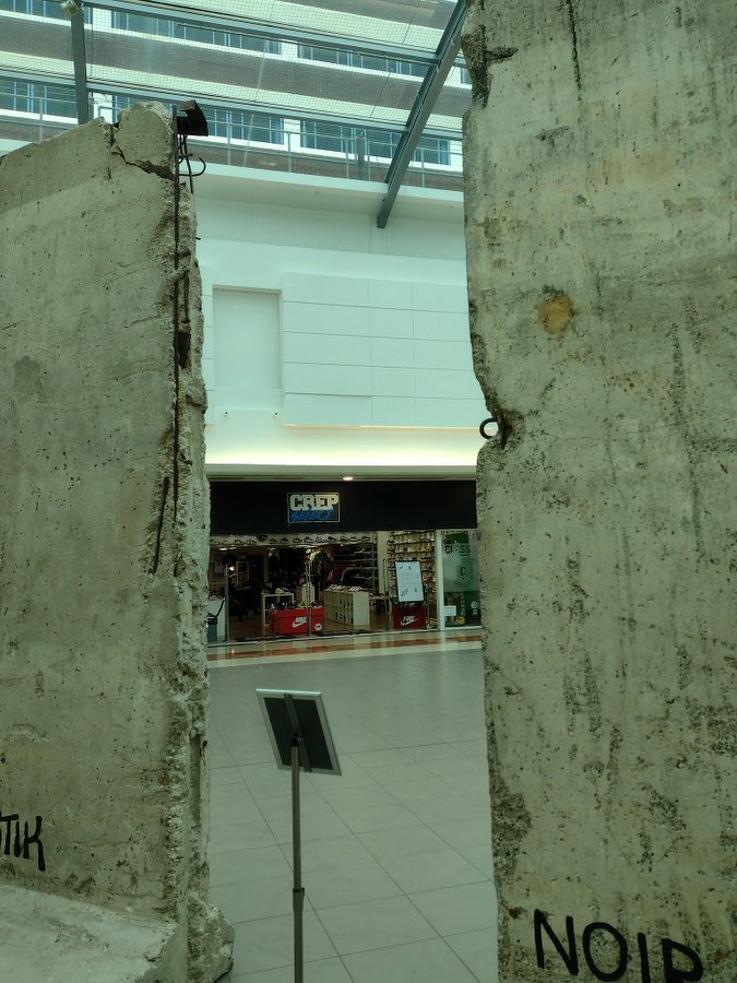 Auto-generated description: Two large concrete slabs are displayed indoors with a store visible in the background.